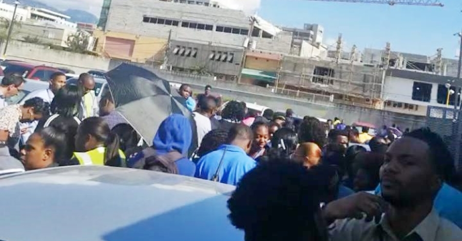 Workers gather in the parking lot of Centre Stage in New Kingston after a 7.7 magnitude earthquake rocked the island today. (Contributed photo)