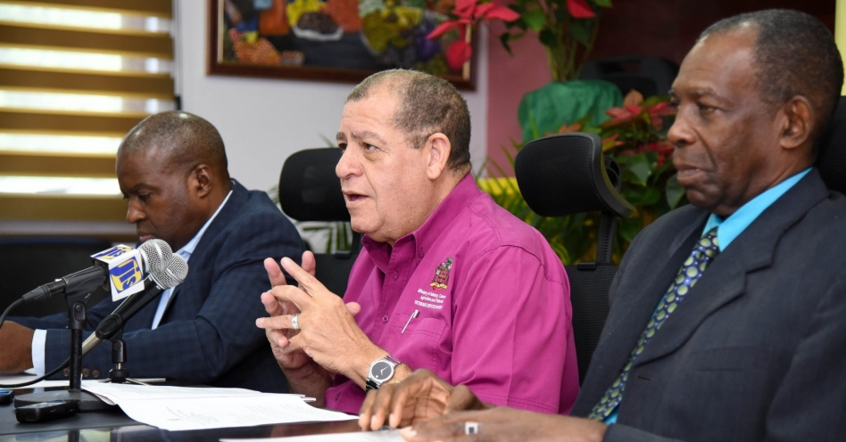 Minister of Industry, Commerce, Agriculture and Fisheries, Hon. Audley Shaw (centre), addressing the quarterly press briefing on Thursday (December 5), at the Ministry's Hope Gardens offices in St. Andrew. He is flanked by Minister without Portfolio, Hon. J.C. Hutchinson (right); and Permanent Secretary, Dermon Spence.