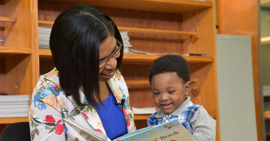 Kedine Matthews Smith reads to her now 10-month-old son, Jonathan, who was diagnosed with dengue fever at six months old. (JIS Photo)