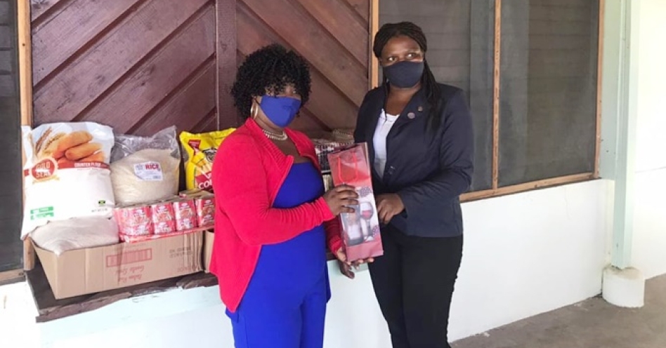 Lieutenant Governor Notoya Williams (right) presenting a member of staff with a token.
