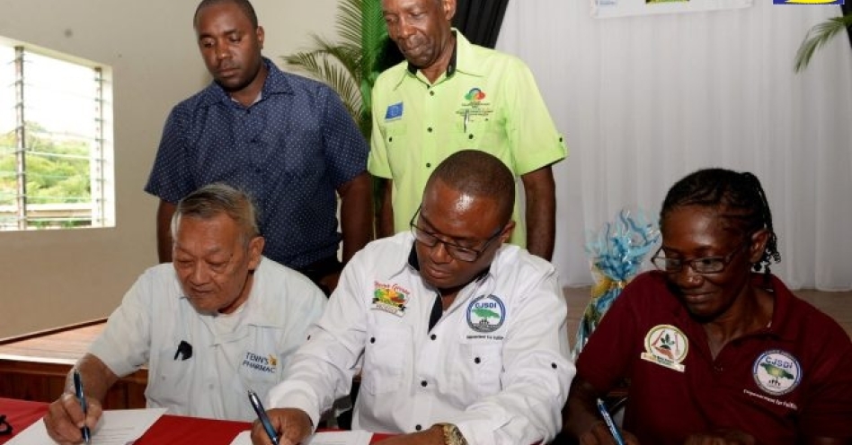 St. Catherine farmer, Alfred Tenn (left); CEO of Home Grown Produce Limited, Damion Young (centre) and St. Elizabeth farmer, Melody Garwood, sign contract for the planting of more red peas, at the launch of the Red Peas Industry Programme, in Spaldings, Clarendon, on November 1. Observing are Chief Agronomist at Bodles Research Centre, Alexi Reid (left) and Minister without Portfolio in the Ministry of Industry, Commerce, Agriculture and Fisheries, Hon. J.C. Hutchinson. (JIS Photo)